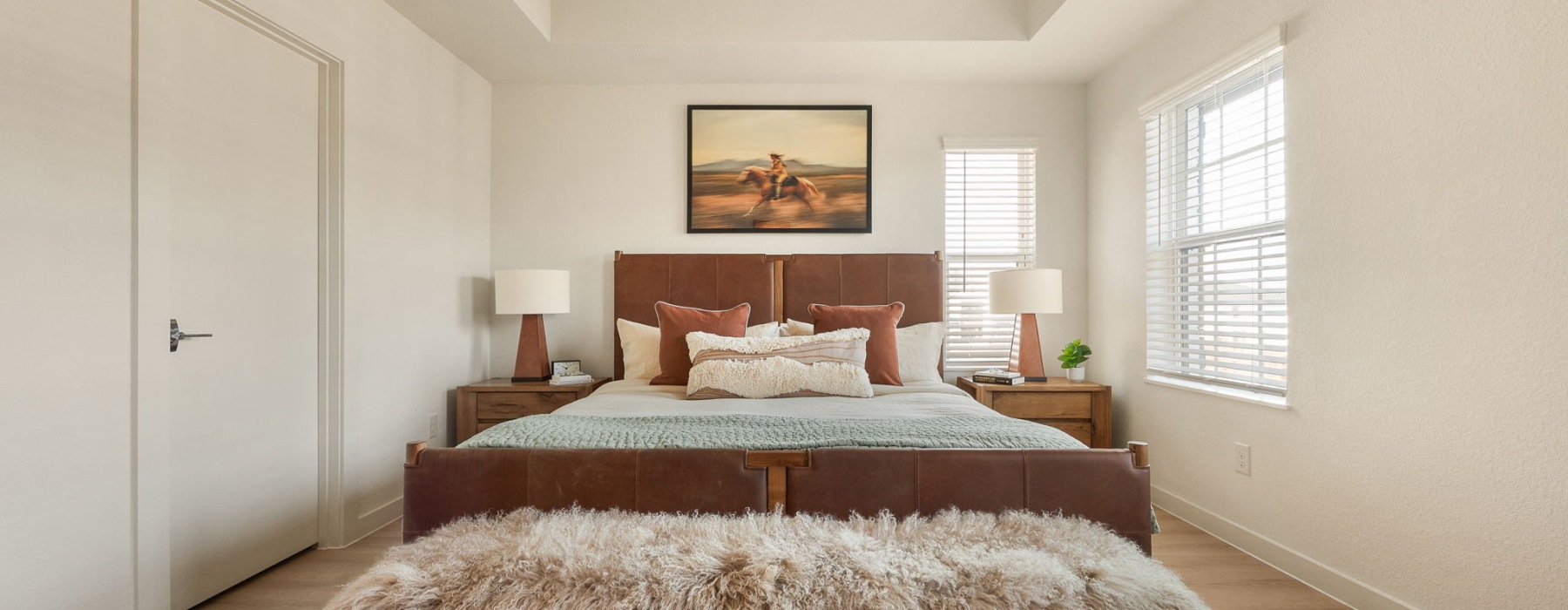 primary bedroom with a king bed and large windows at a BTR community